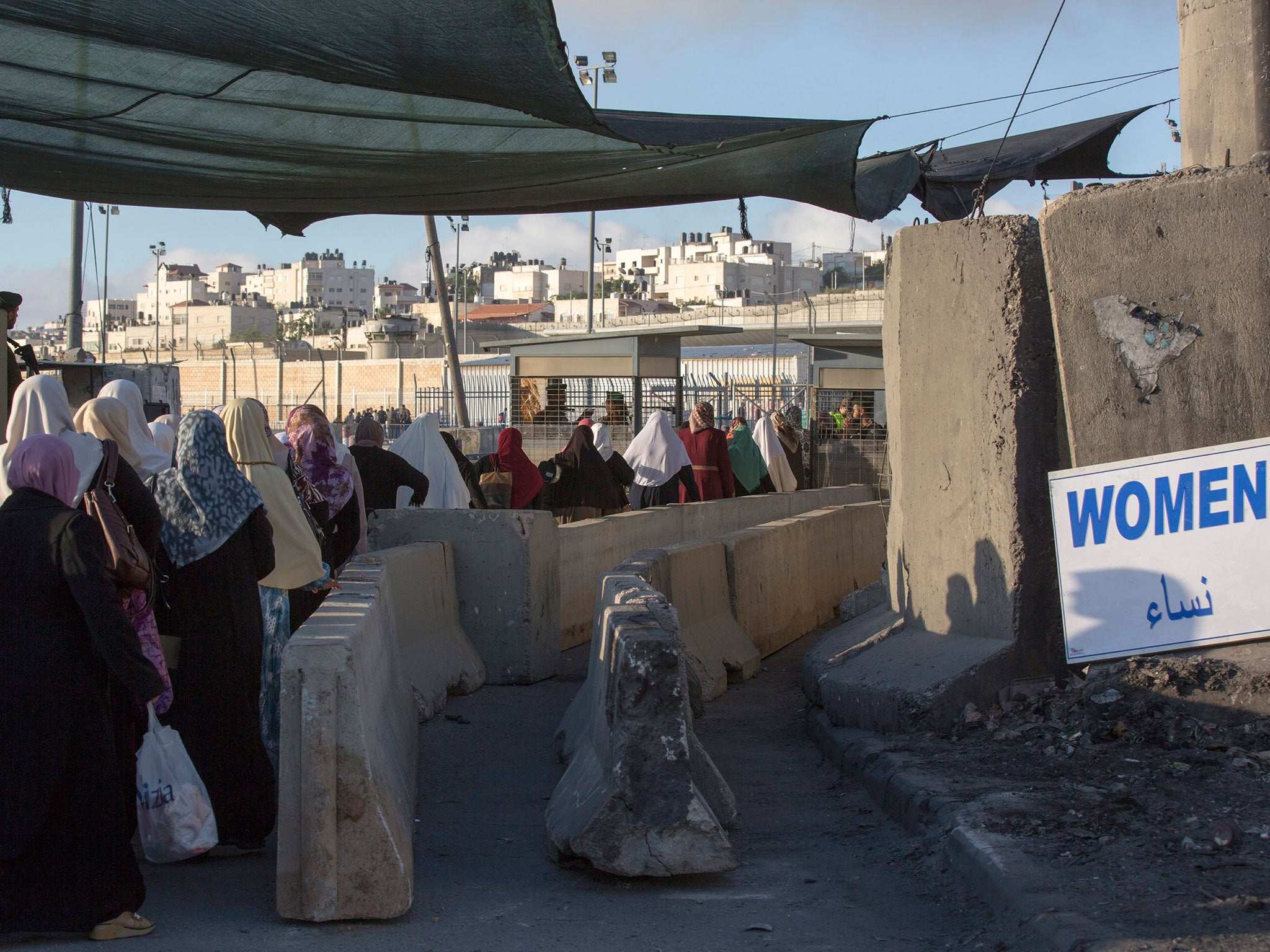 Palestinian women from the West Bank make their way through Qalandia checkpoint into East Jerusalem to attend the first Friday prayers of Ramadan at Al-Aqsa Mosque