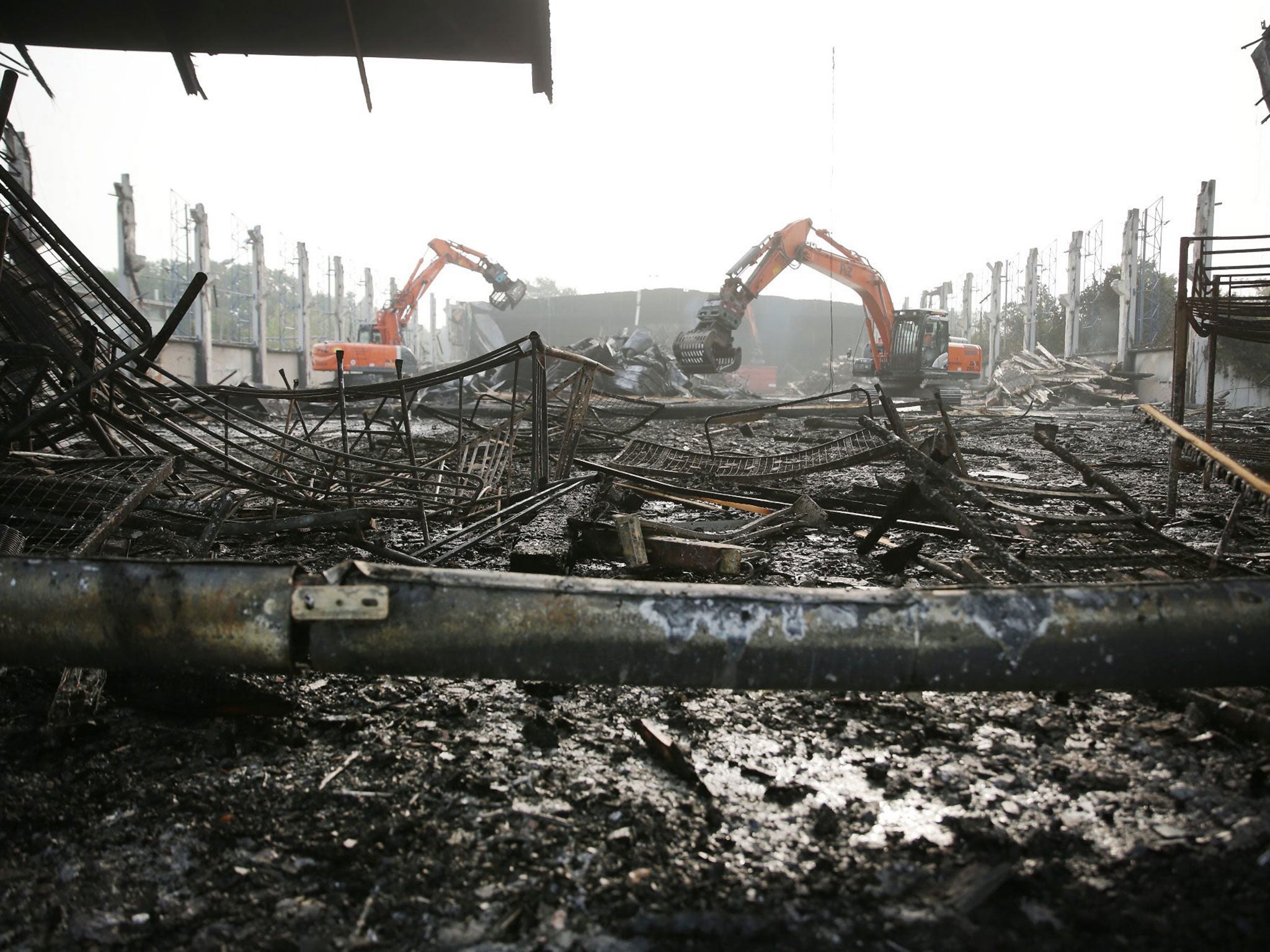 Excavators tear down a burnt down hall at Messe Duesseldorf, Germany, 8 June 2016.