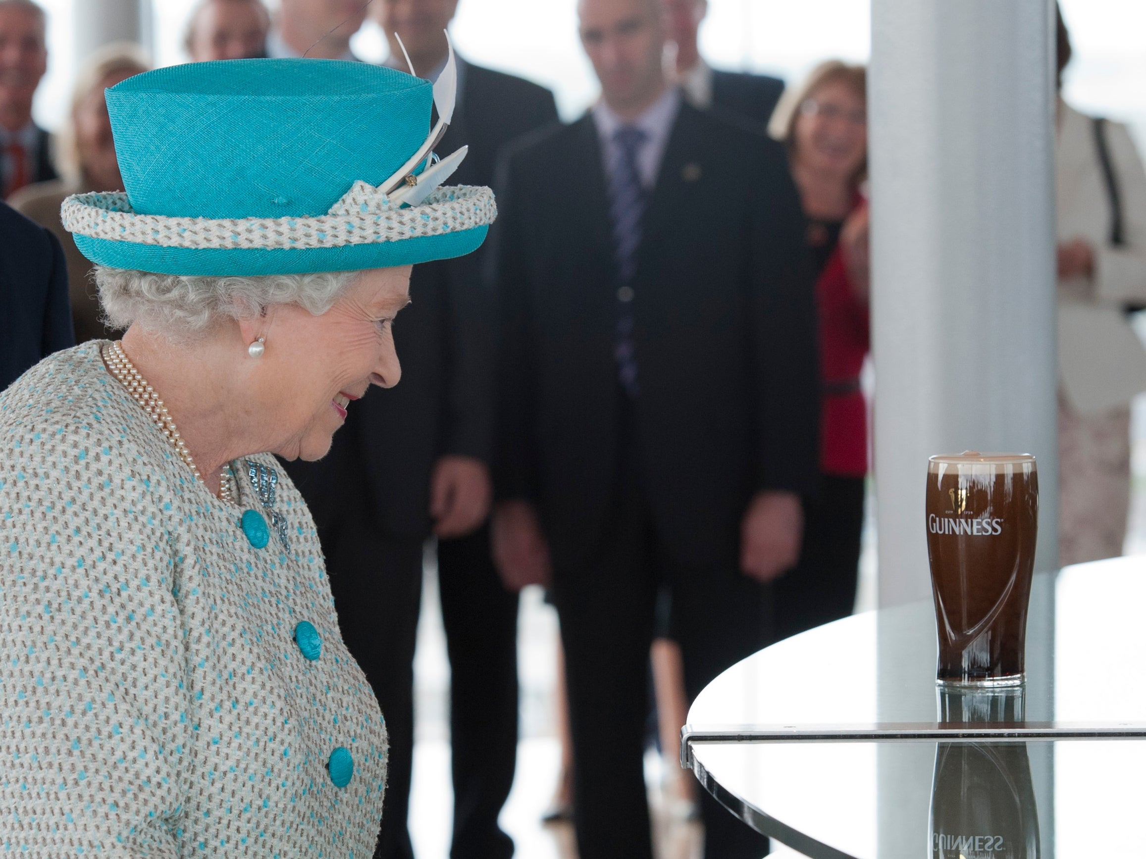 Queen Elizabeth II watches a pint of Guinness being poured as they visit the Guinness Storehouse in 2011