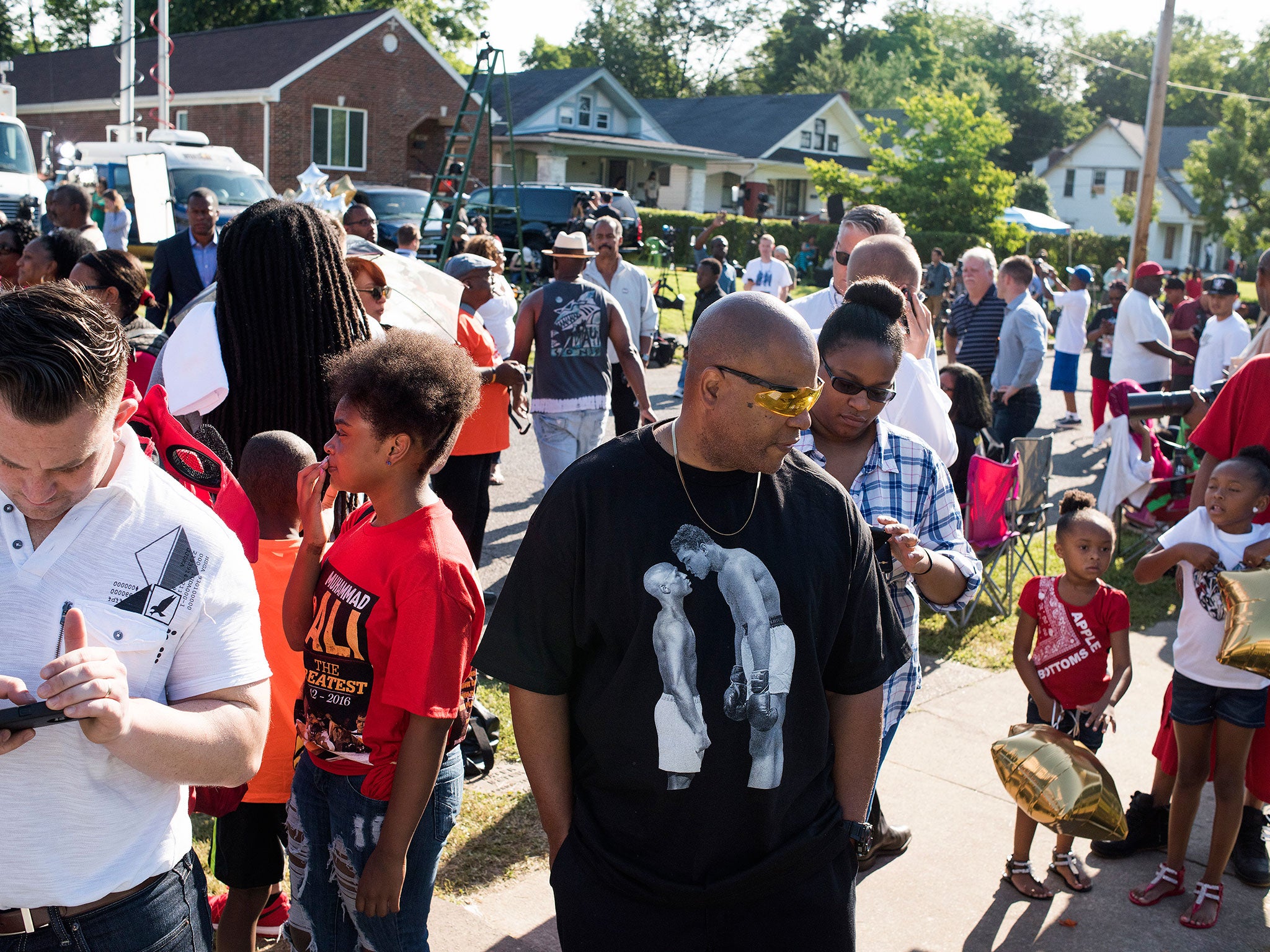 People gather on Grand Avenue in front of Muhammad Ali's childhood home
