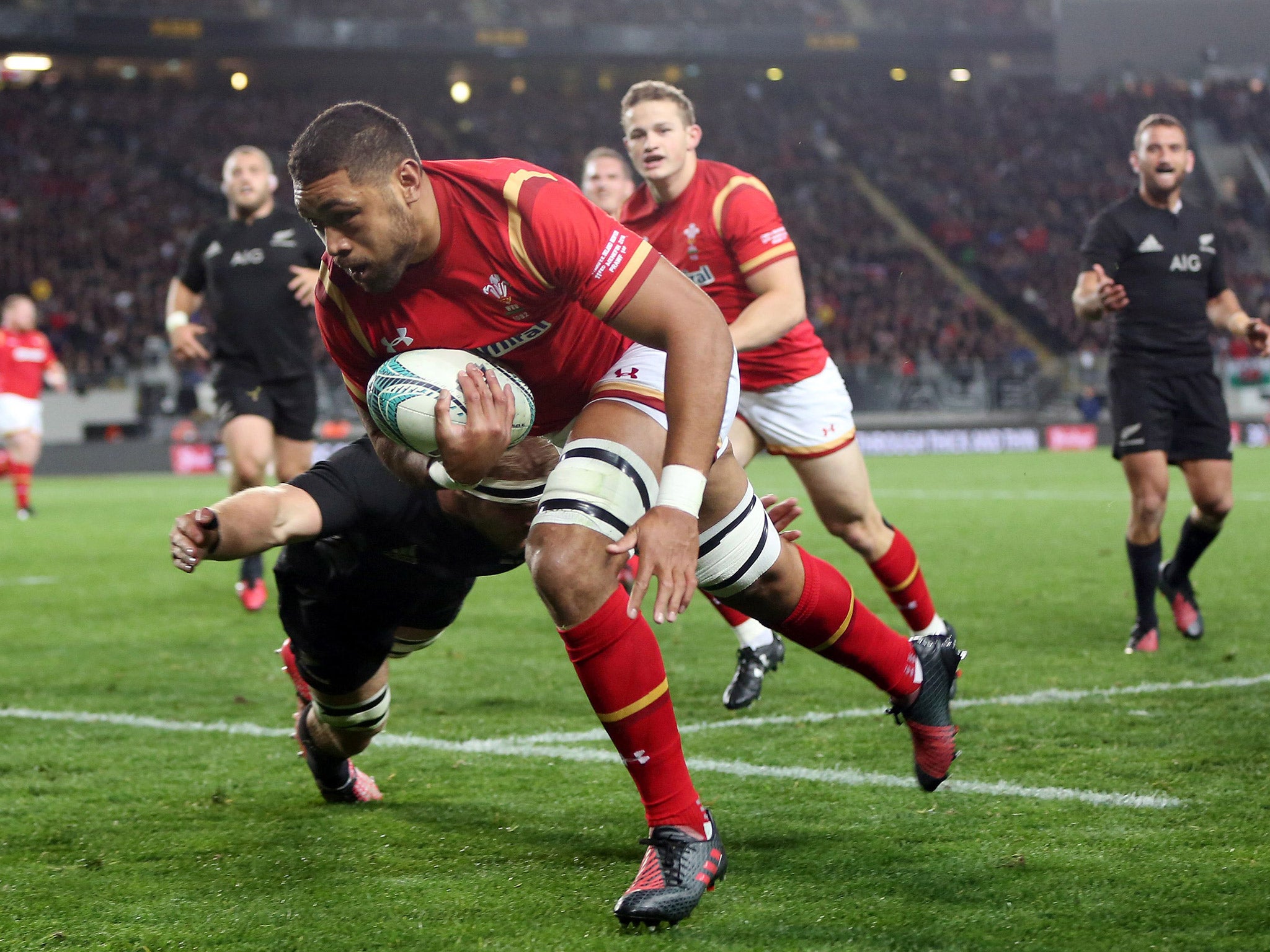 Taulupe Faletau evades the tackle attempt of Sam Cane to score a try