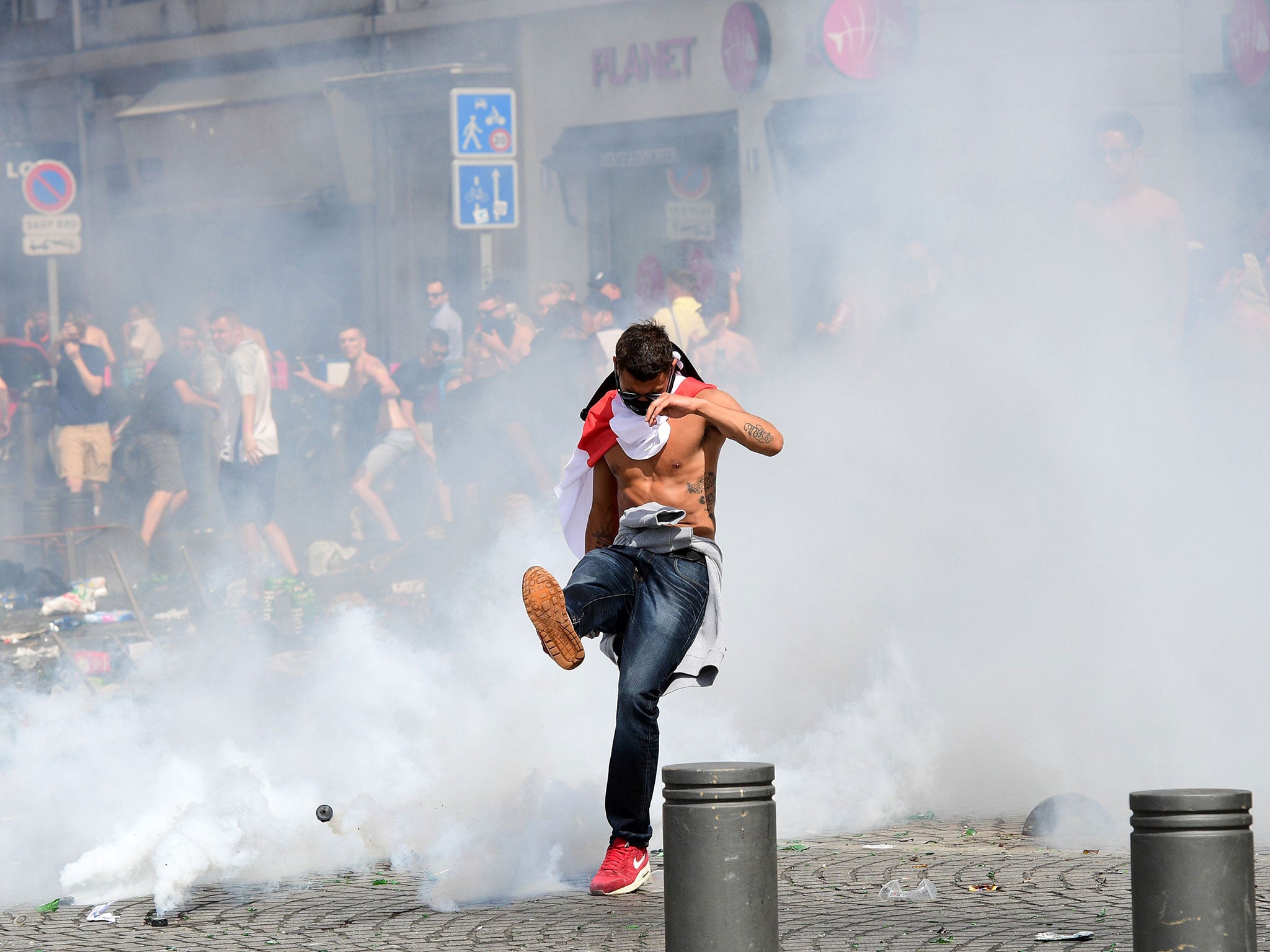 An England fan kicks away a tear gas canister after tear gas was released by French police in the city of Marseille, southern France, on June 11, 2016 (AFP/Getty Images)