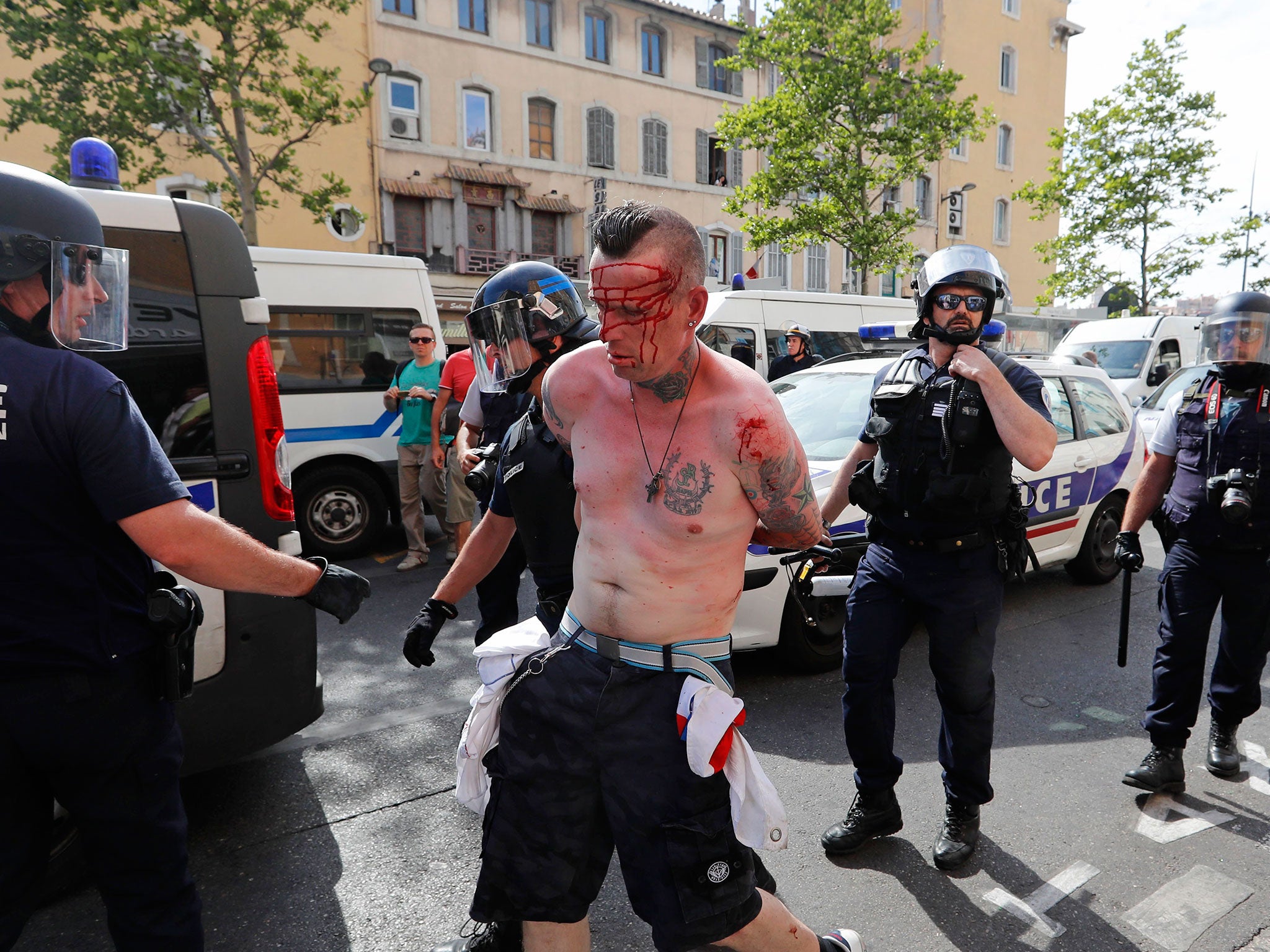 A man is arrested by police officers in downtown Marseille, France, Saturday, June 11, 2016.
