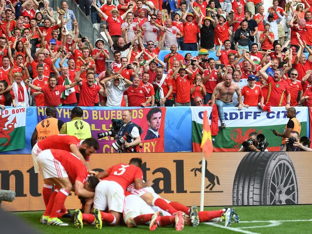 Wales players and fans celebrate in unison after Hal Robson-Kanu's winning goal