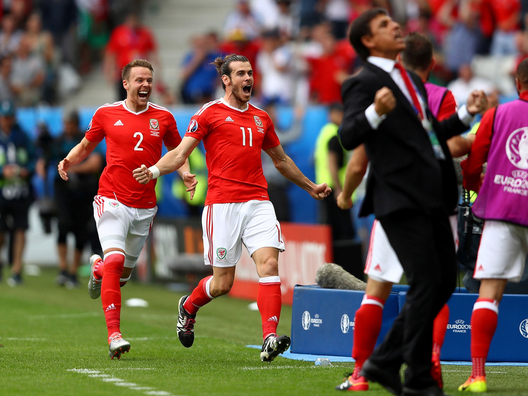Gareth Bale sprints to his team-mates as Chris Coleman celebrates Wales taking the lead