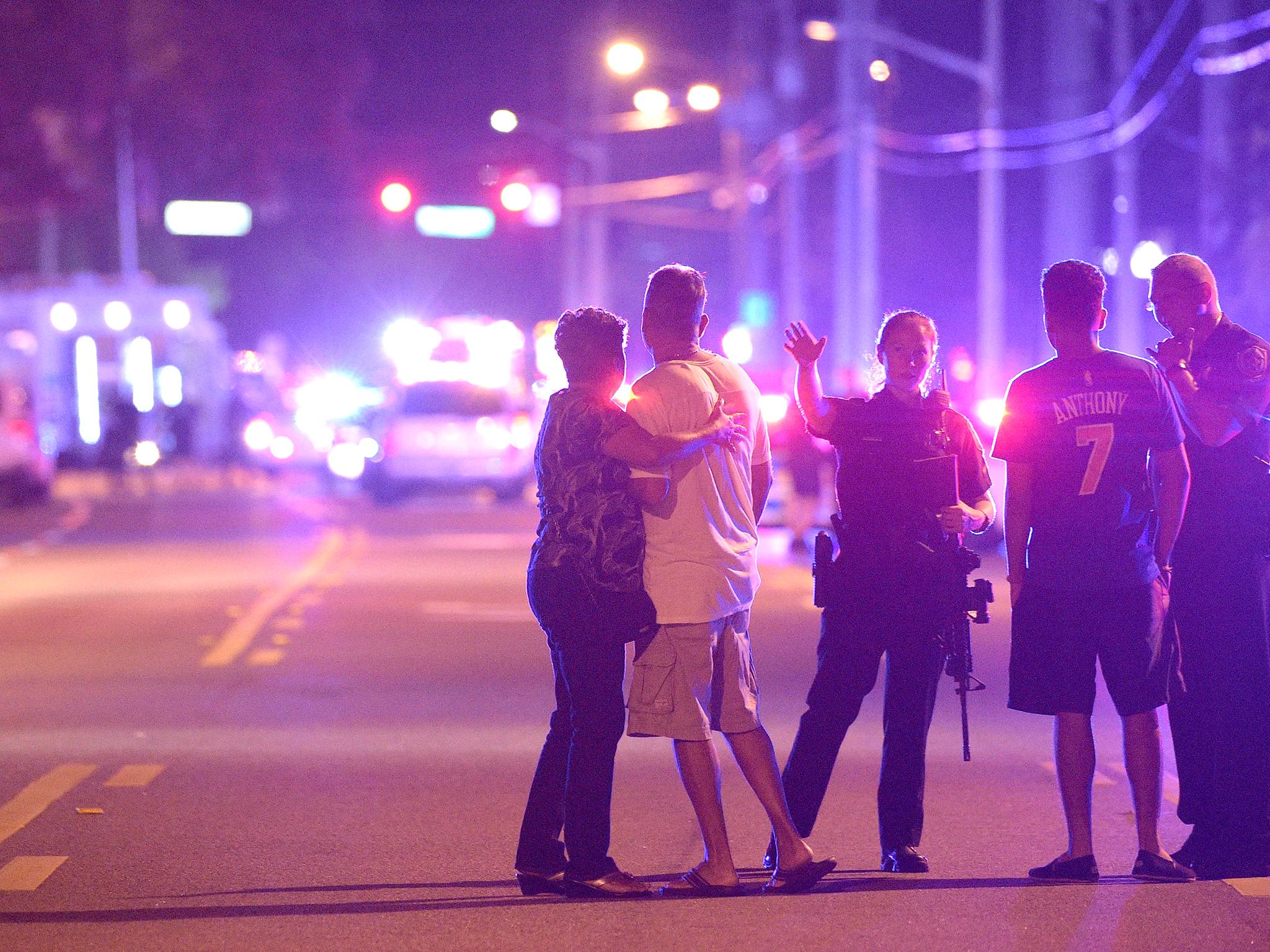 Orlando Police officers direct family members away from a multiple shooting at a nightclub
