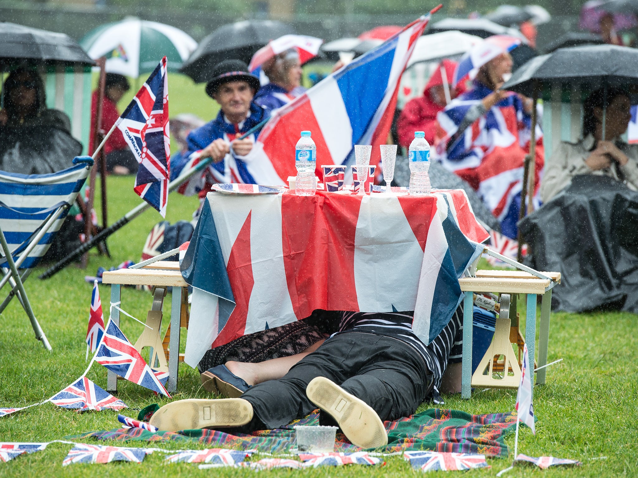 Guests take shelter under a table after the rain becomes too much to endure