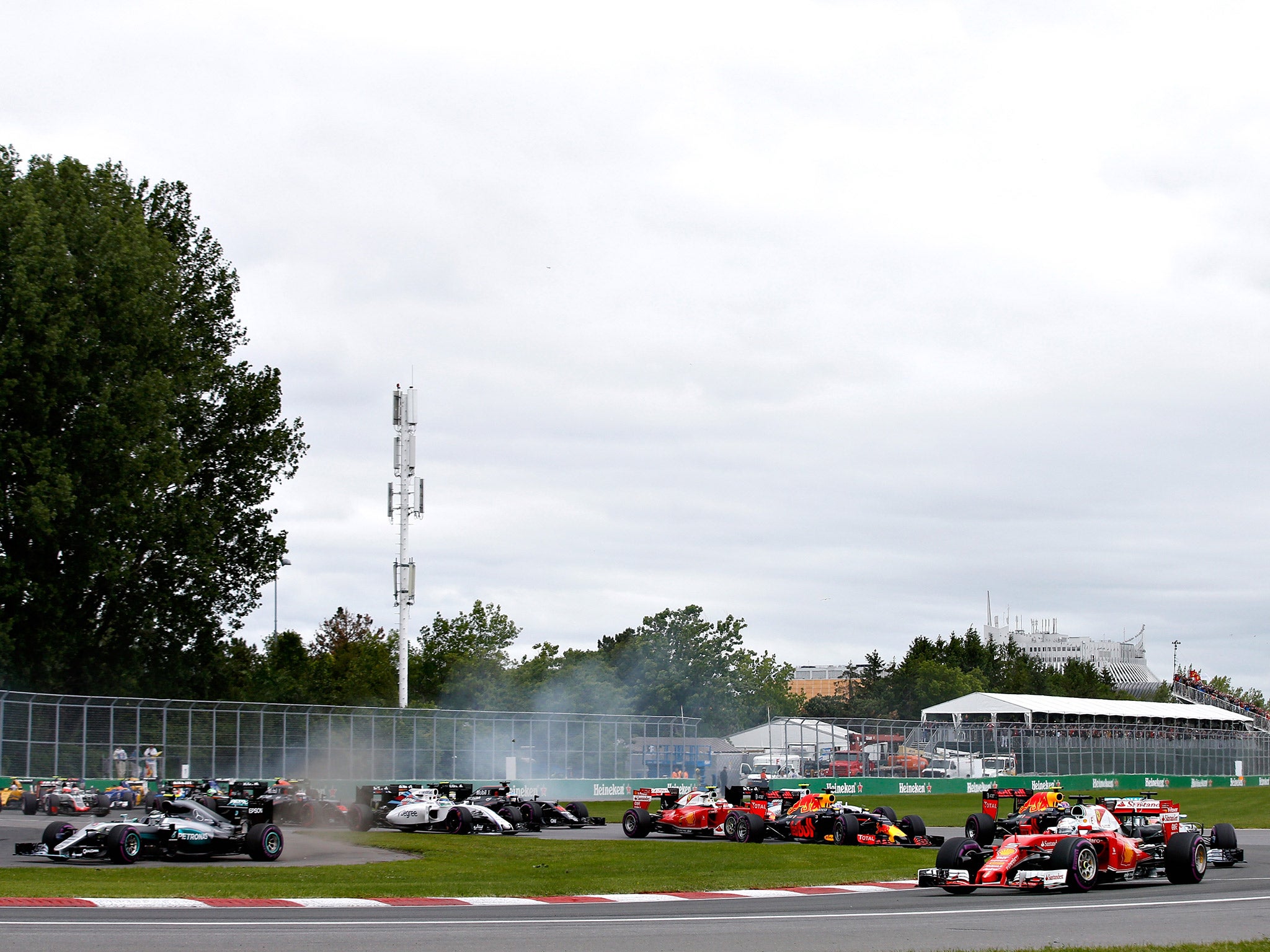 Sebastian Vettel leads the field into turn one as Nico Rosberg cuts the first corner