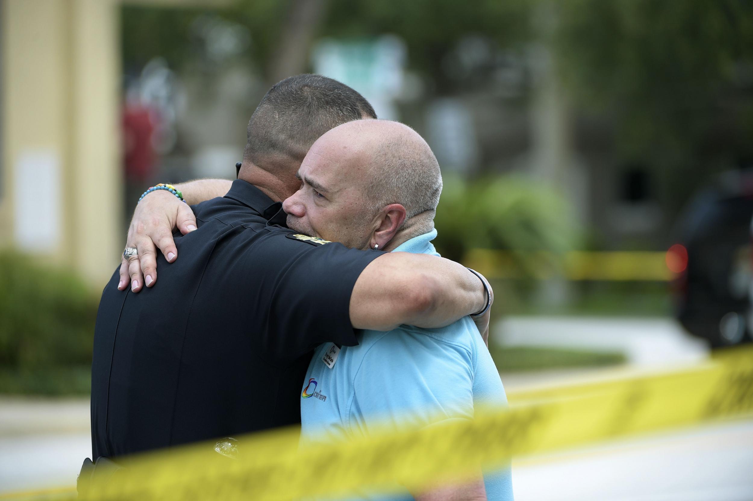 Police officer gives hug to Terry DeCarlo, executive director of LGBT Center of Central Florida