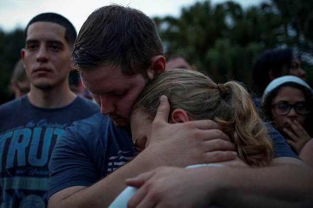 Savannah is embraced by her friend Ricky during a vigil to commemorate victims of a mass shooting at the Pulse gay night club in Orlando, Florida, June 12, 2016. Savannah said she lost a friend in the shooting