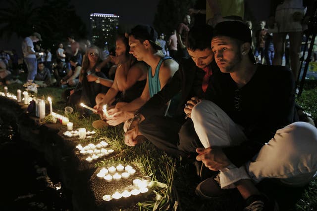 Pulse regulars Johnpaul Vazquez, right, and his boyfriend Yazan Sale, mourn the dead at a vigil in downtown Orlando on Sunday