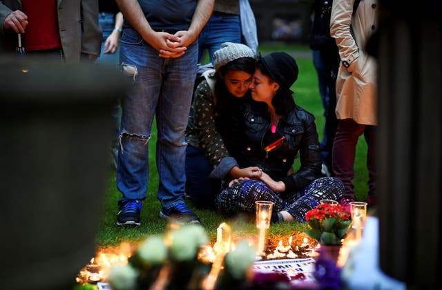 Mourners embrace during a candle-lit vigil, in memory of the victims of the gay nightclub mass shooting in Orlando, at St Anne's Church in the Soho