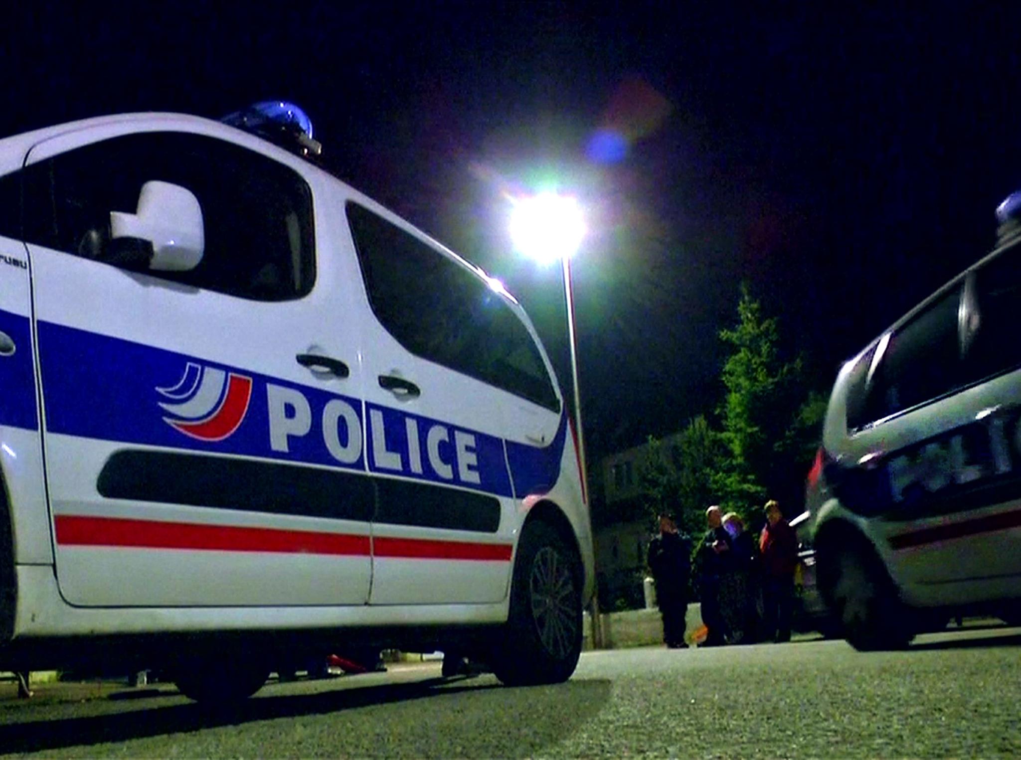 Police vehicles at the scene near where a French police commander was stabbed to death in front of his home in the Paris suburb of Magnanville