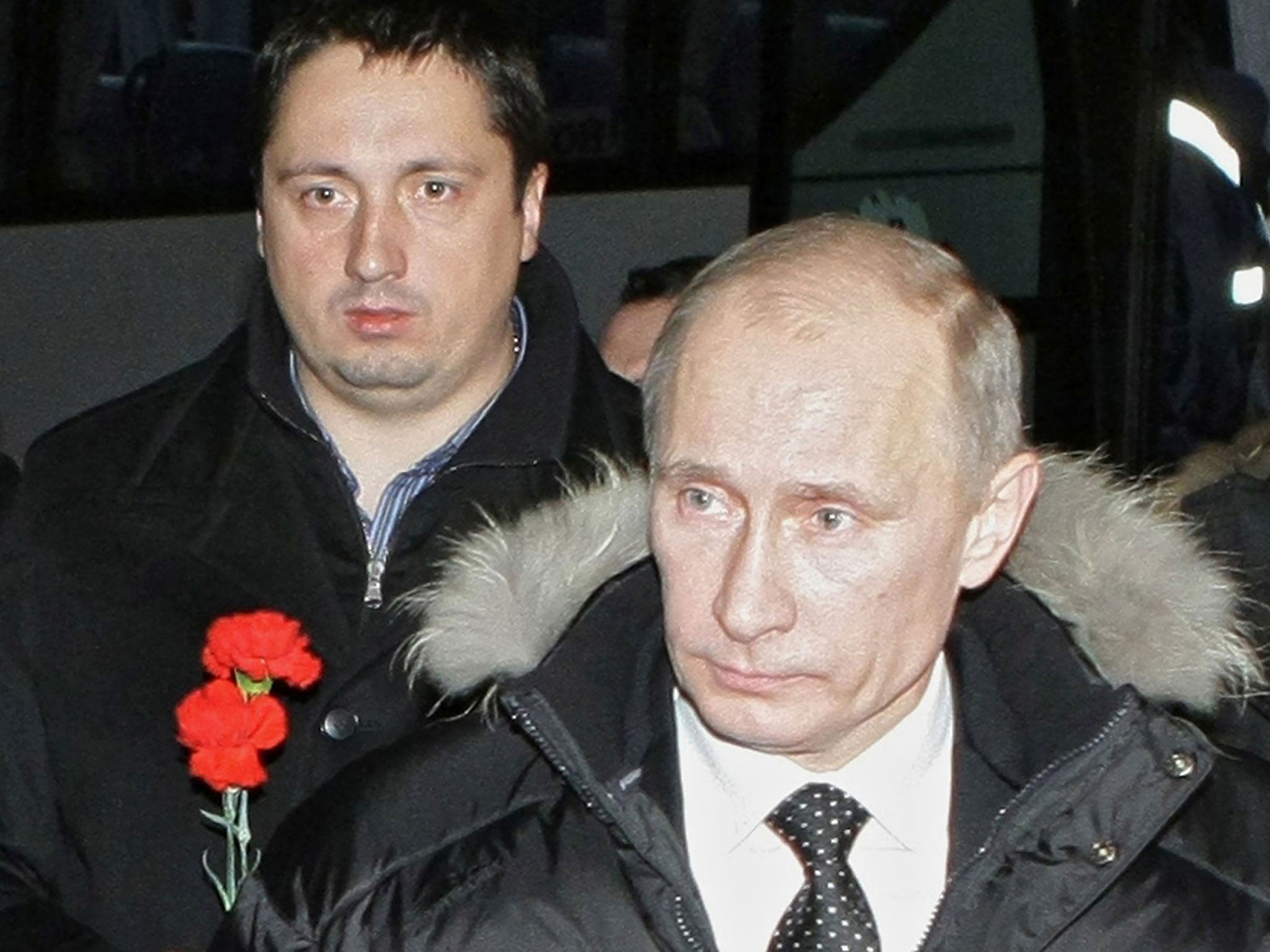 This file photo taken on December 21, 2010 shows then Russian Prime Minister Vladimir Putin (R) and Russia's football supporters association head Alexander Shprygin walking to lay flowers at the grave of slain Spartak Moscow fan Yegor Sviridov in Moscow
