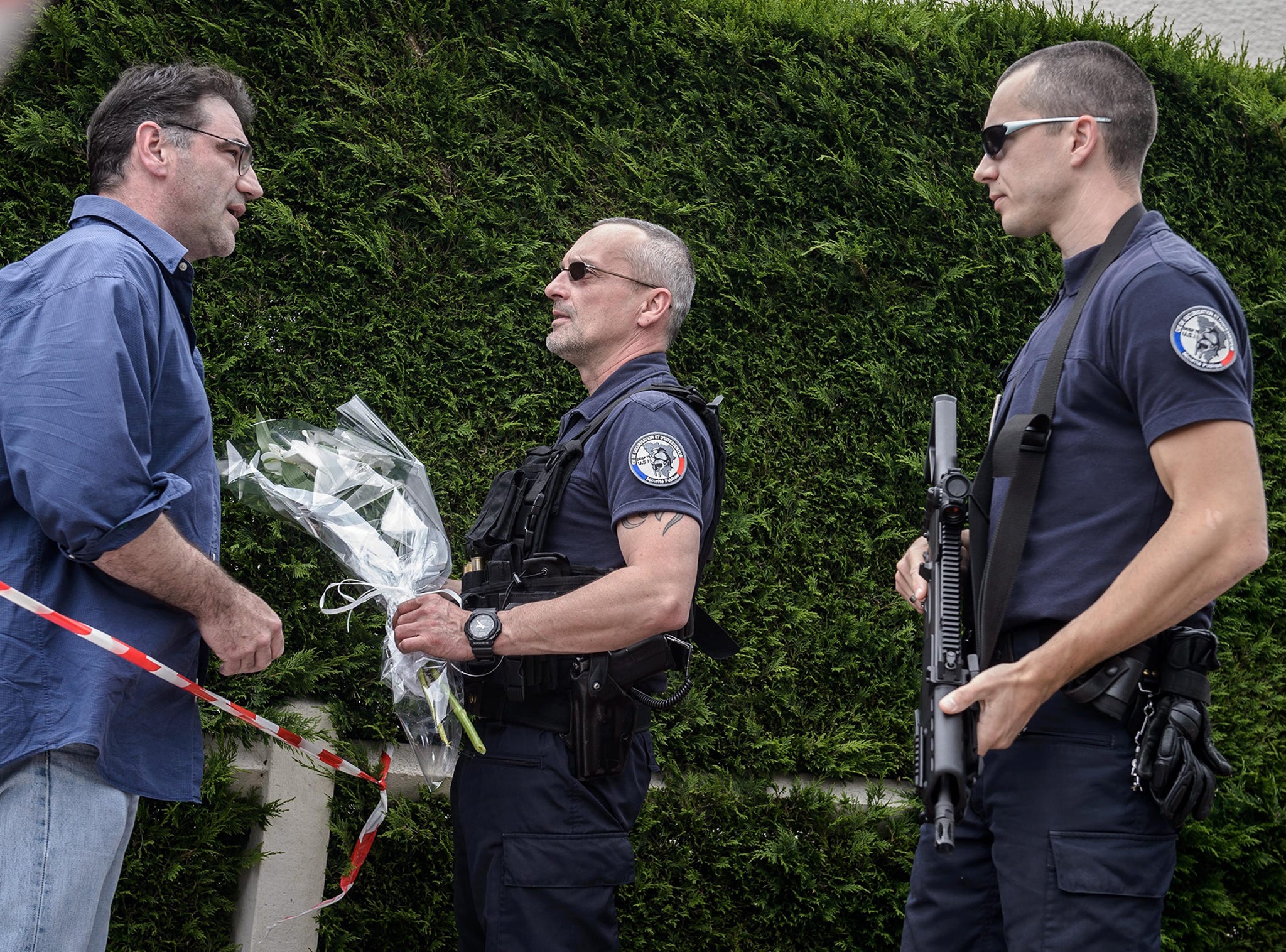 A local resident giving flowers to Police officers standing guard at a security perimeter near the home in Manganville