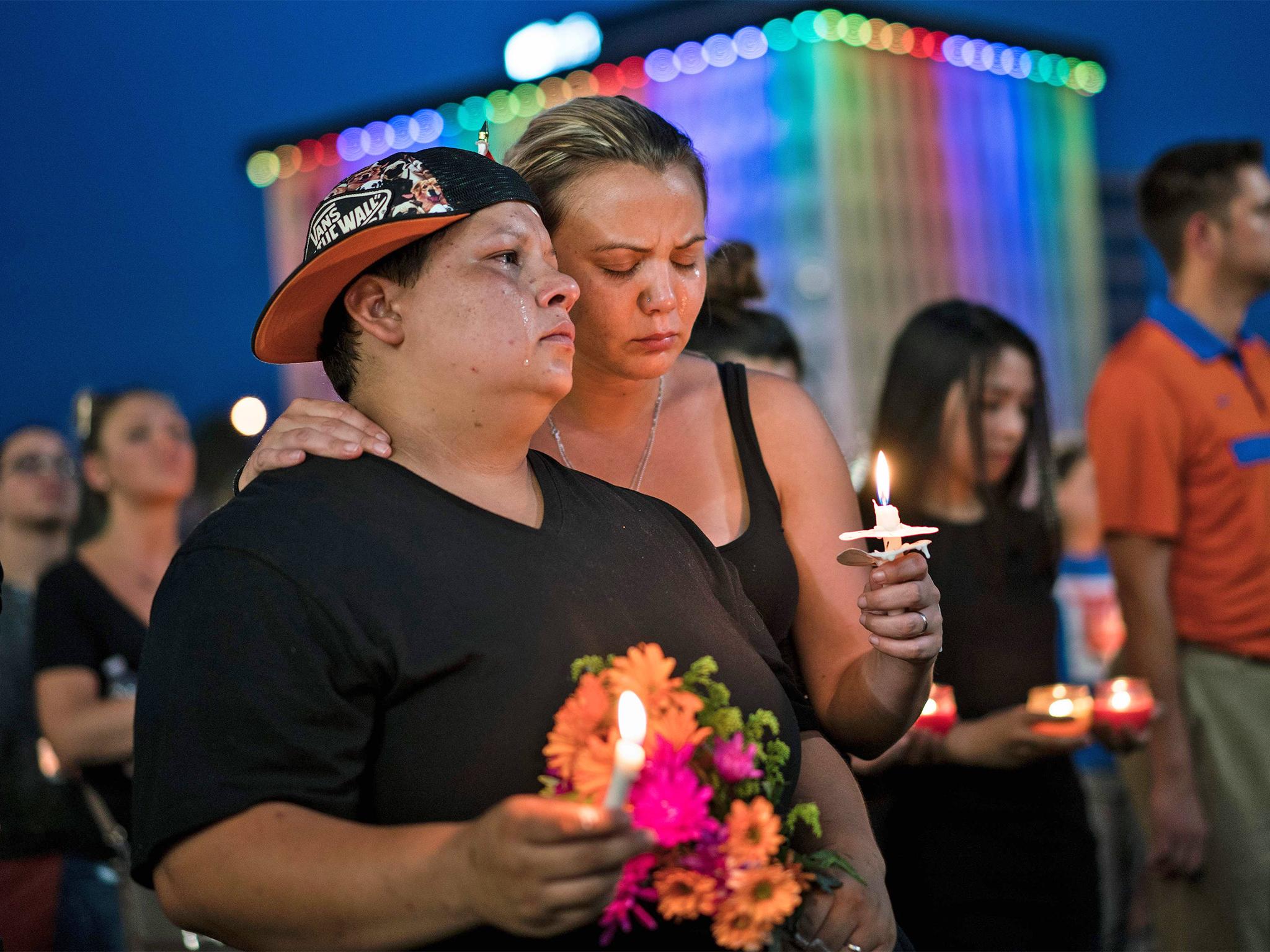 Nicole Edwards and her wife Kellie Edwards observe a moment of silence during a vigil outside the Dr. Phillips Center for the Performing Arts for the mass shooting victims at the Pulse nightclub June 13, 2016 in Orlando, Florida.