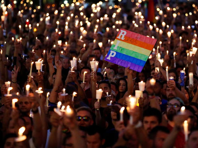 People take part in a candlelight memorial service the day after a mass shooting at the Pulse gay nightclub in Orlando
