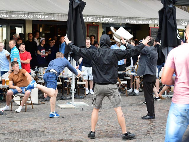 A Russian football supporter lobs a chair towards Slovakian fans sitting in a cafe in Lille