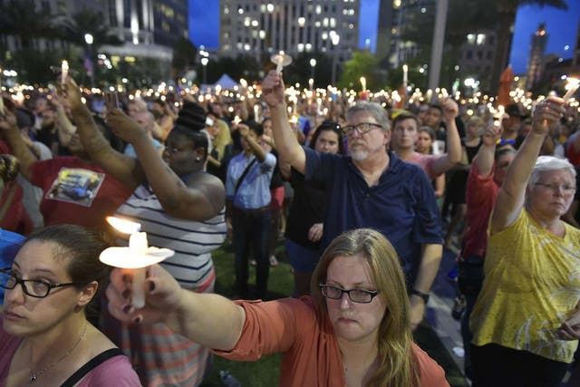 People hold a vigil for the Orlando shooting victims.