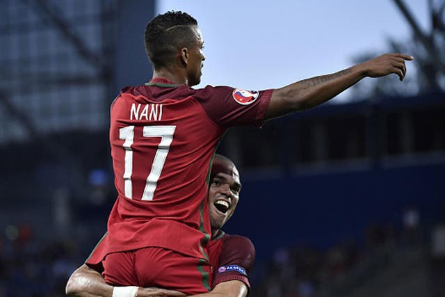Pepe holds aloft colleague Nani after the midfielder opened the scoring against Iceland from close range (Getty)