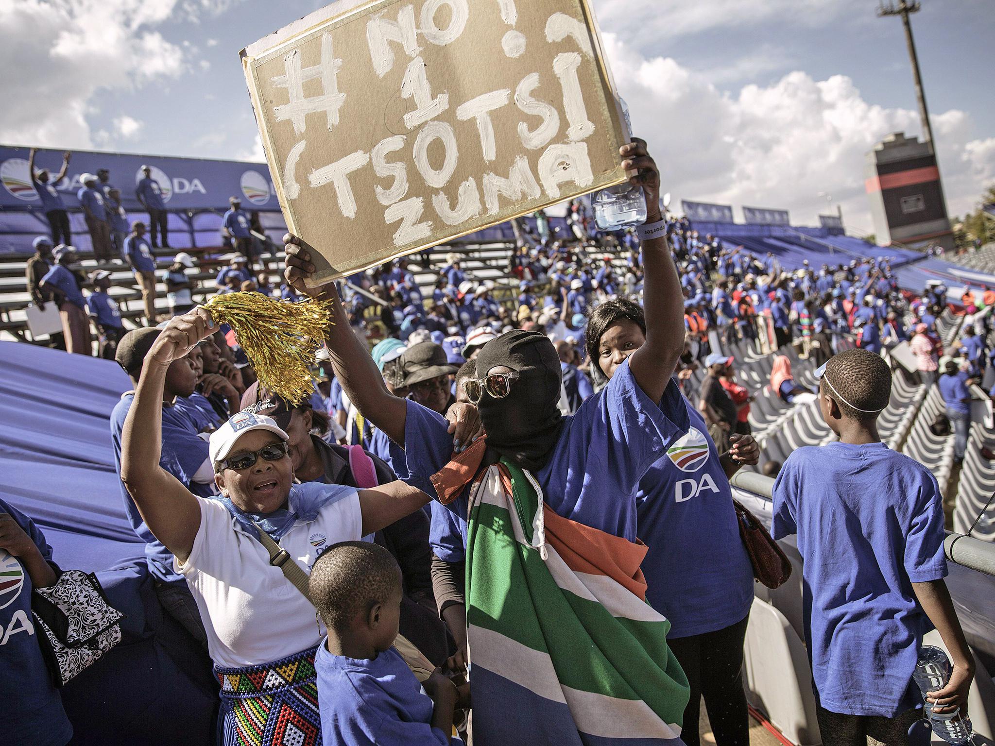Main opposition party Democratic Alliance supporters hold banners mocking the president, in Johannesburg. 'Tsotsi' means gangster