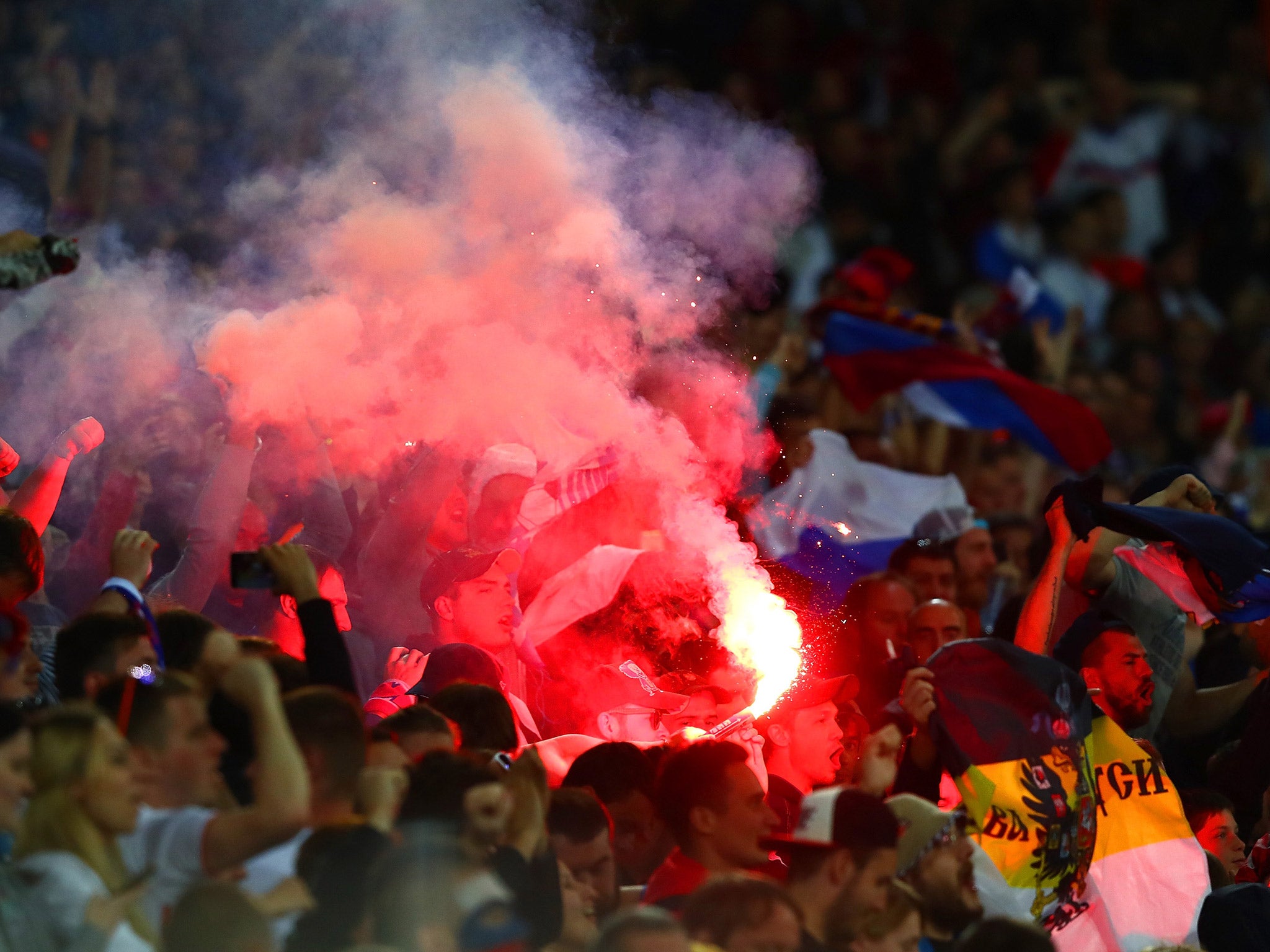 Russia fans light a flare in the Lille Metropole stands after Denis Glushikov's goal