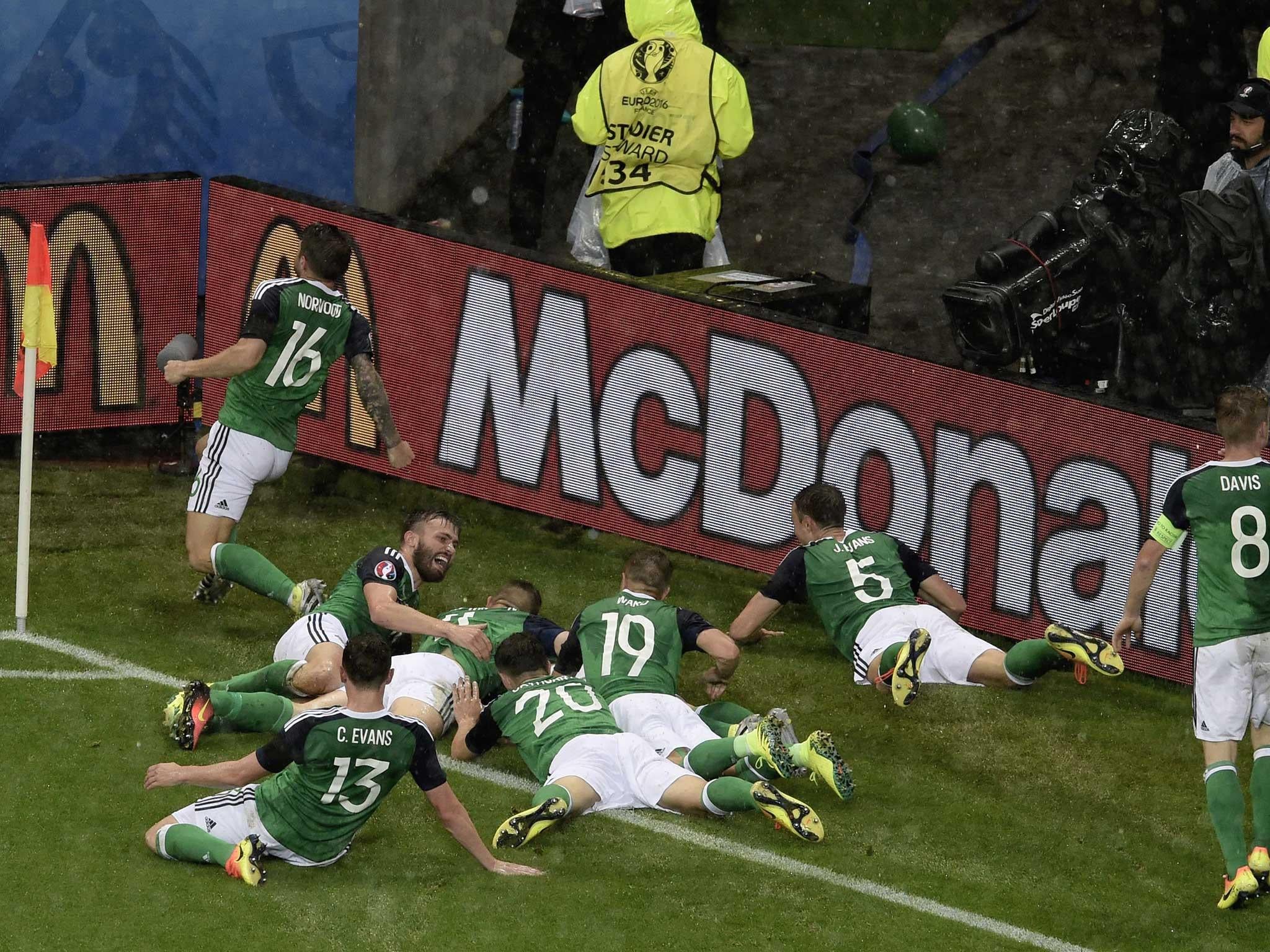 Gareth McAuley is mobbed by his team-mates after scoring the opener