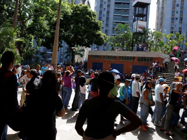 People queue outside a supermarket in the Venezuelan capital Caracas