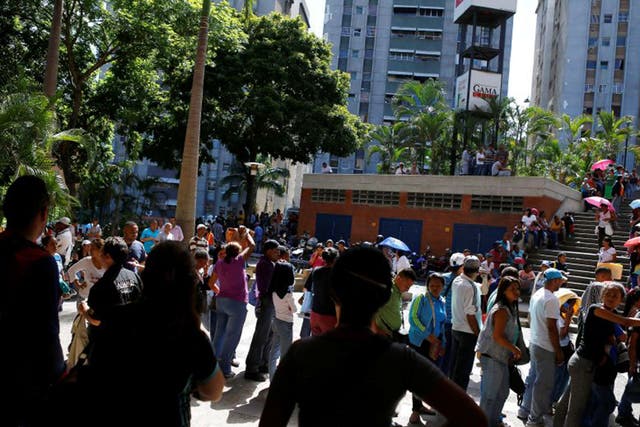 People queue outside a supermarket in the Venezuelan capital Caracas