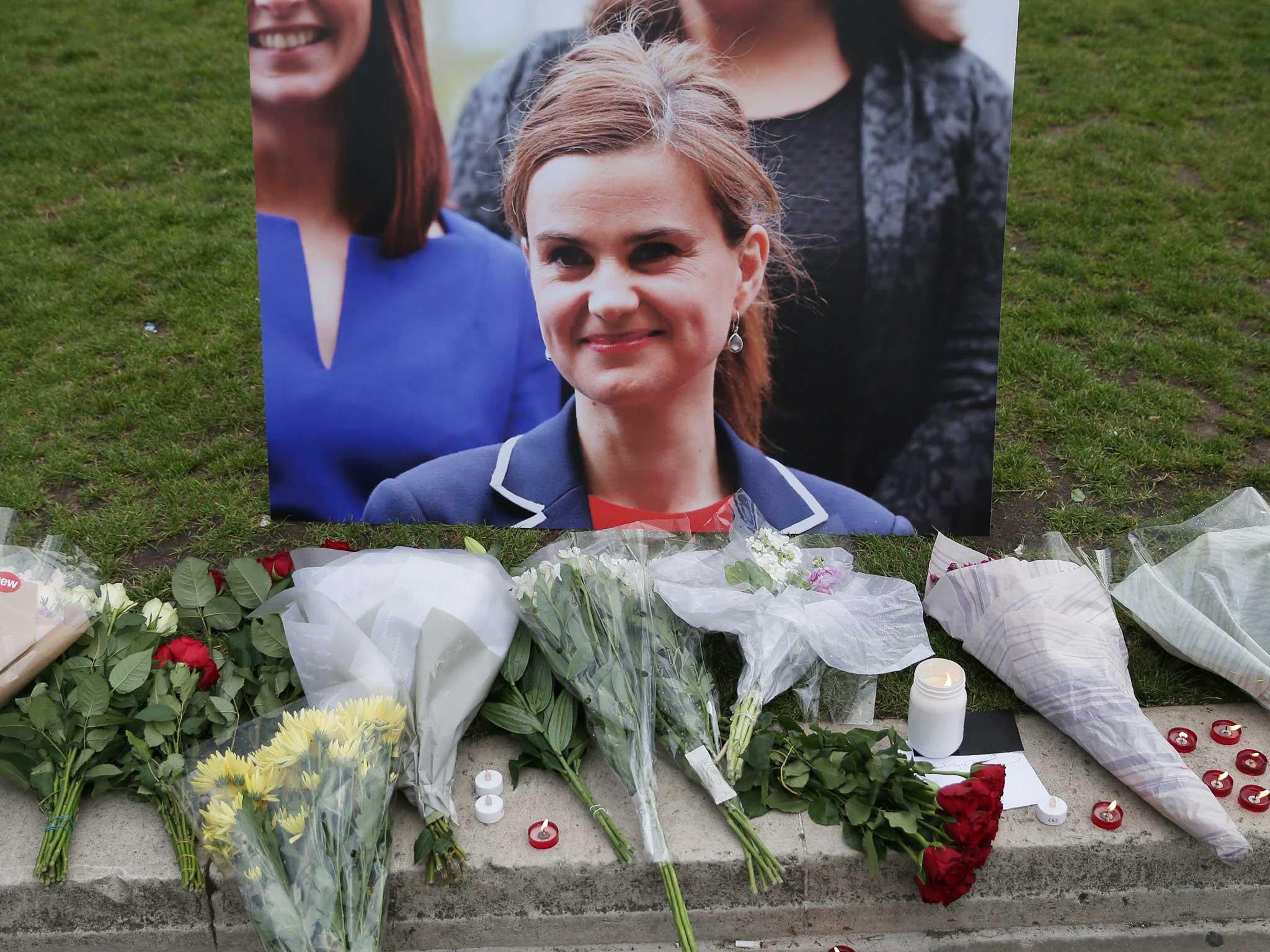 Floral tributes and candles are placed by a picture of Labour MP Jo Cox