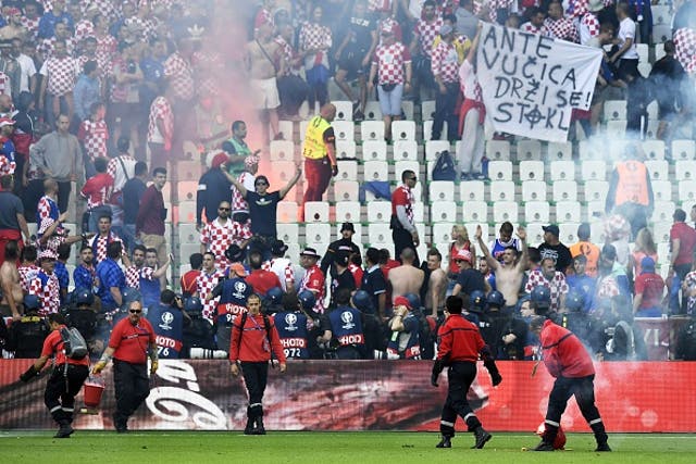 Stewards attempt to clear the pitch in Saint-Etienne as Croatia supporters taunt riot police
