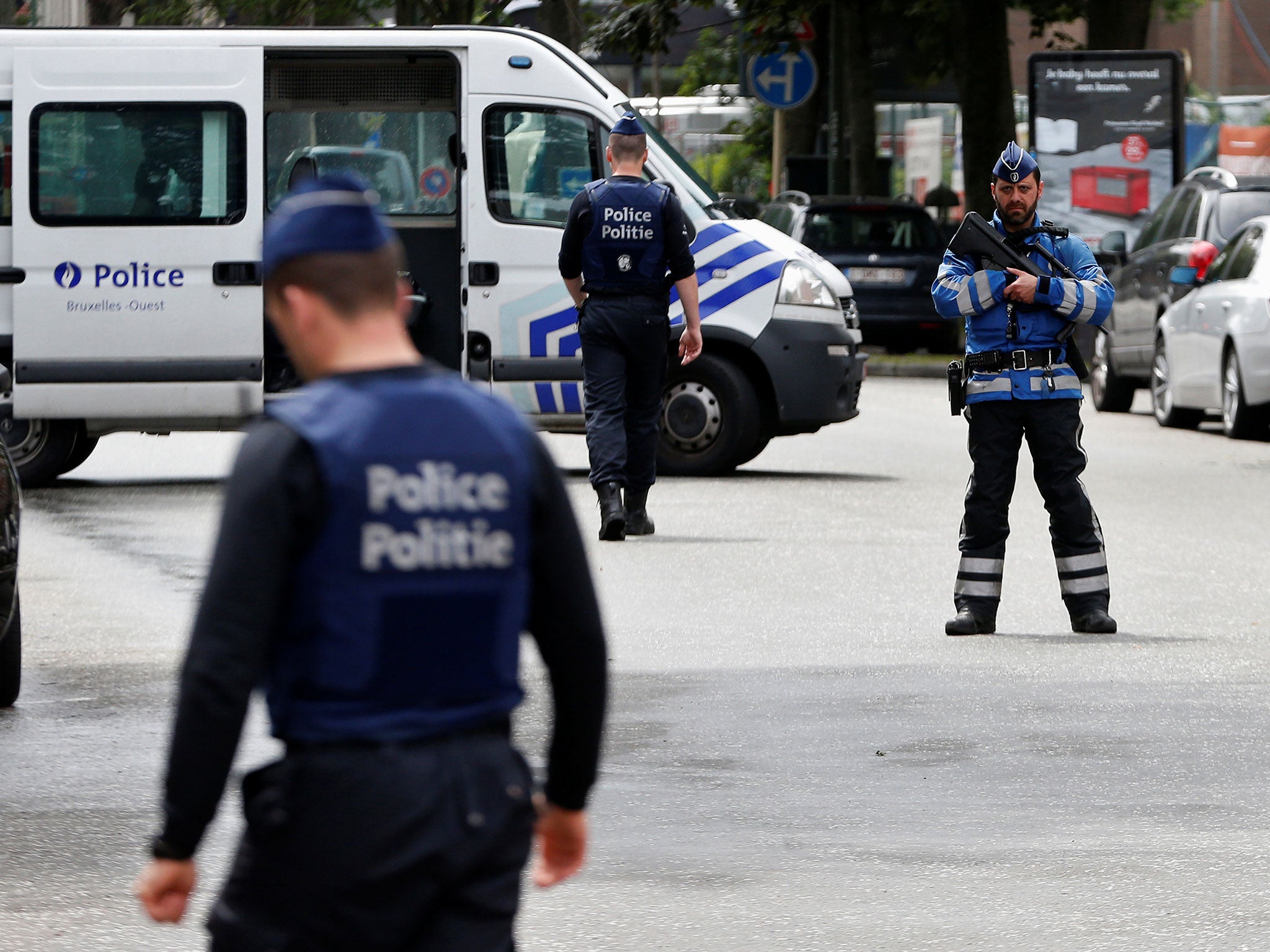 Belgian police officers stand guard near an apartment building during the reconstruction in the Brussels district of Etterbeek