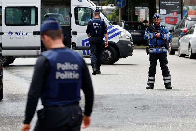  Belgian police officers stand guard near an apartment building during the reconstruction in the Brussels district of Etterbeek