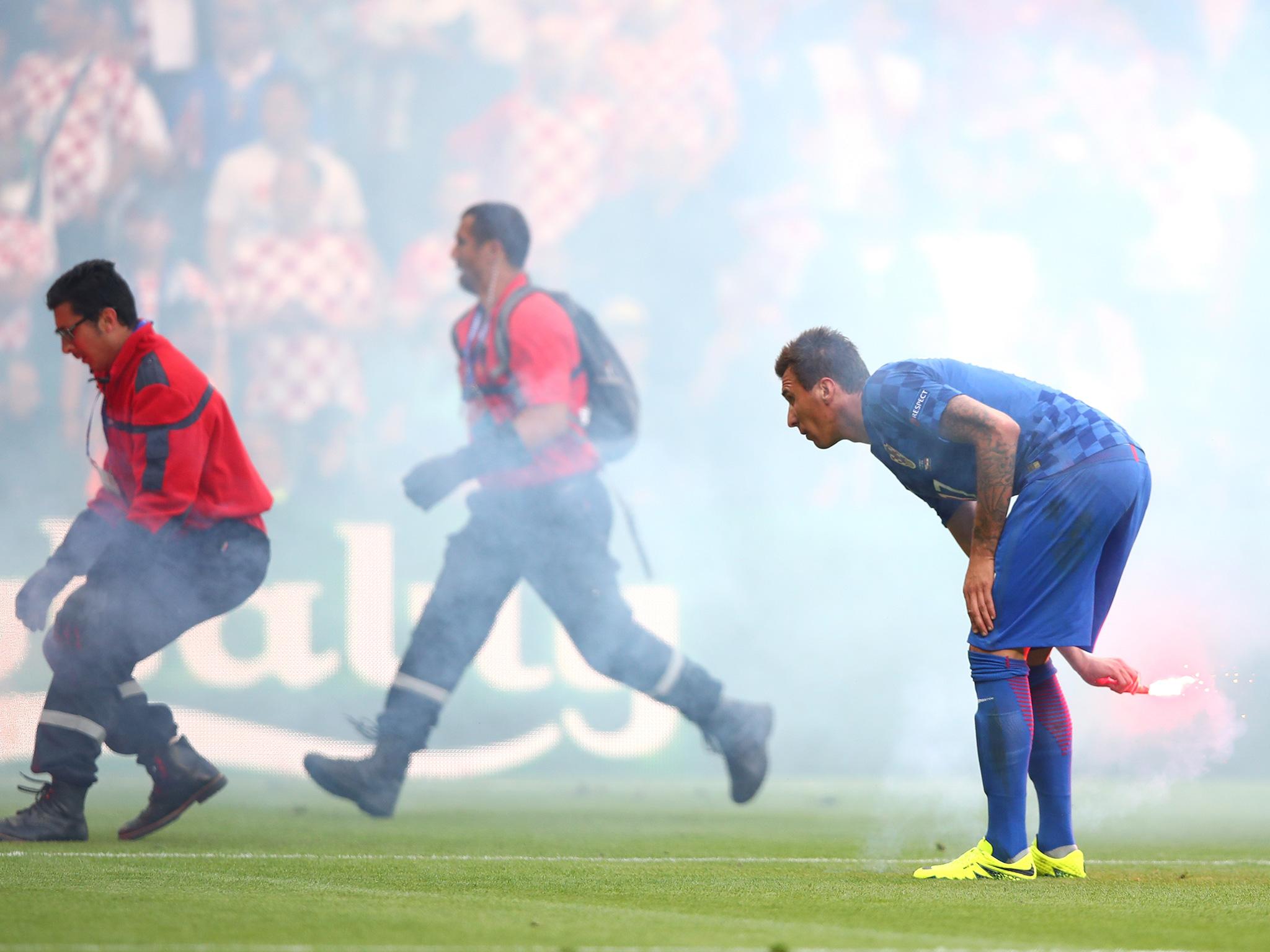 Mario Mandzukic, the Croatia striker, removing a flare from the field