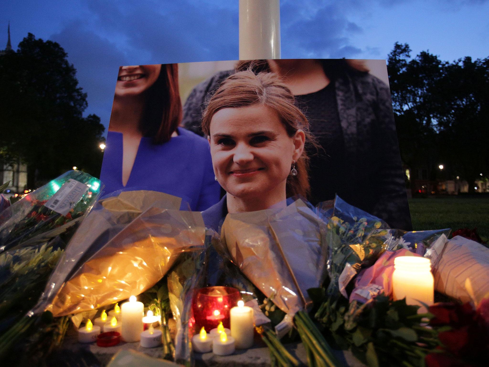 Floral tributes and candles are placed by a picture of slain Labour MP Jo Cox at a vigil in Parliament square in London on 16 June, 2016