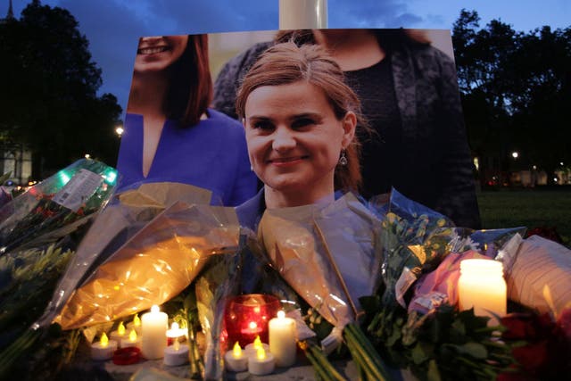 Floral tributes and candles are placed by a picture of slain Labour MP Jo Cox at a vigil in Parliament square in London on 16 June, 2016