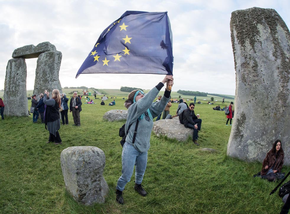 A woman waves an EU flag at Stonehenge on the longest day of the year