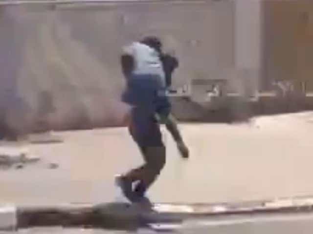 The grainy footage shows the soldier carrying the civilian on his shoulder as he dashes out from shelter, amid the sound of shouting and gunfire in Fallujah, Iraq