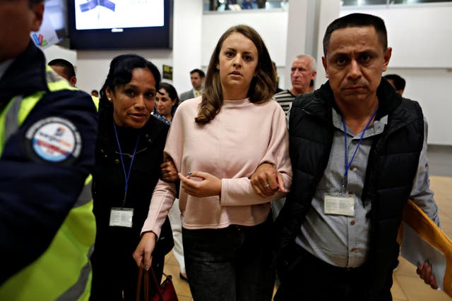 Melissa Reid, 22, is escorted by immigration officers before boarding a flight at Lima's airport in Callao, Peru