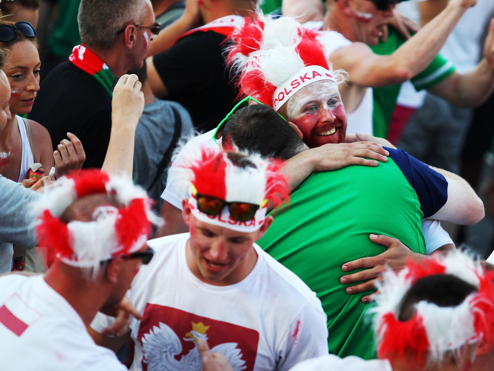 A Polish and Northern Irish fan embrace at one of Euro 2016's fan parks