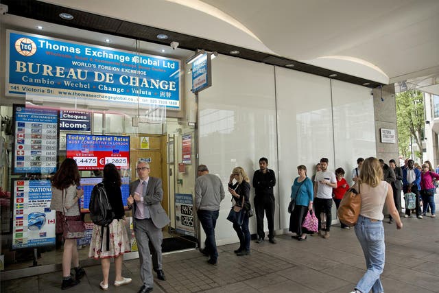 People queue for currency at a foreign exchange bureau in London yesterday