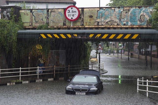 A car is abandoned under a bridge in Battersea after getting stuck in floodwater water