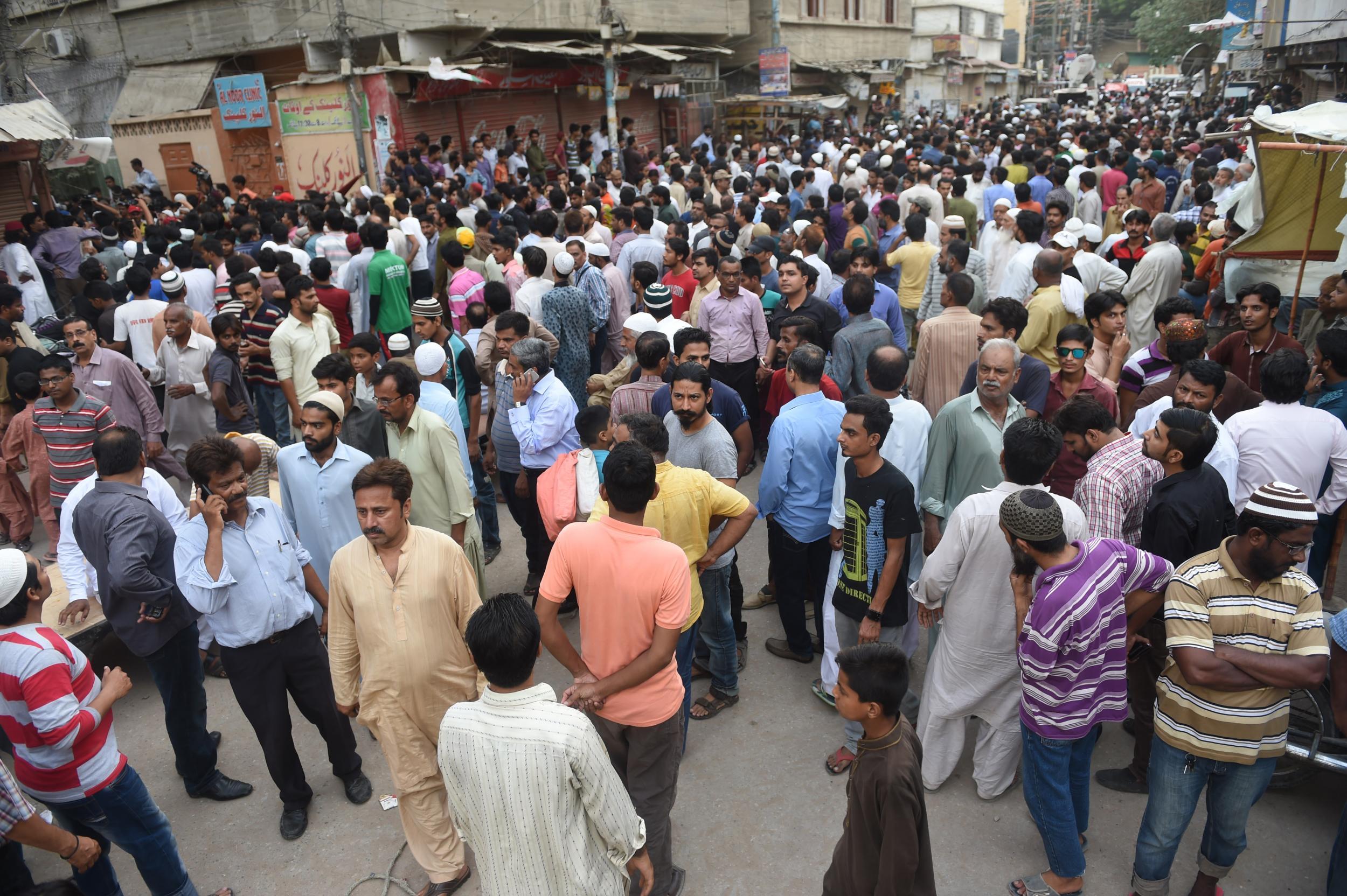 Fans, relatives and local residents gather outside of Amjad Sabri's home in Karachi