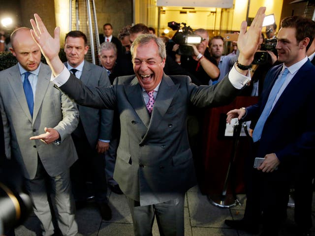 Nigel Farage, the leader of the UK Independence Party, celebrates and poses for photographers as he leaves a "Leave.EU" organization party