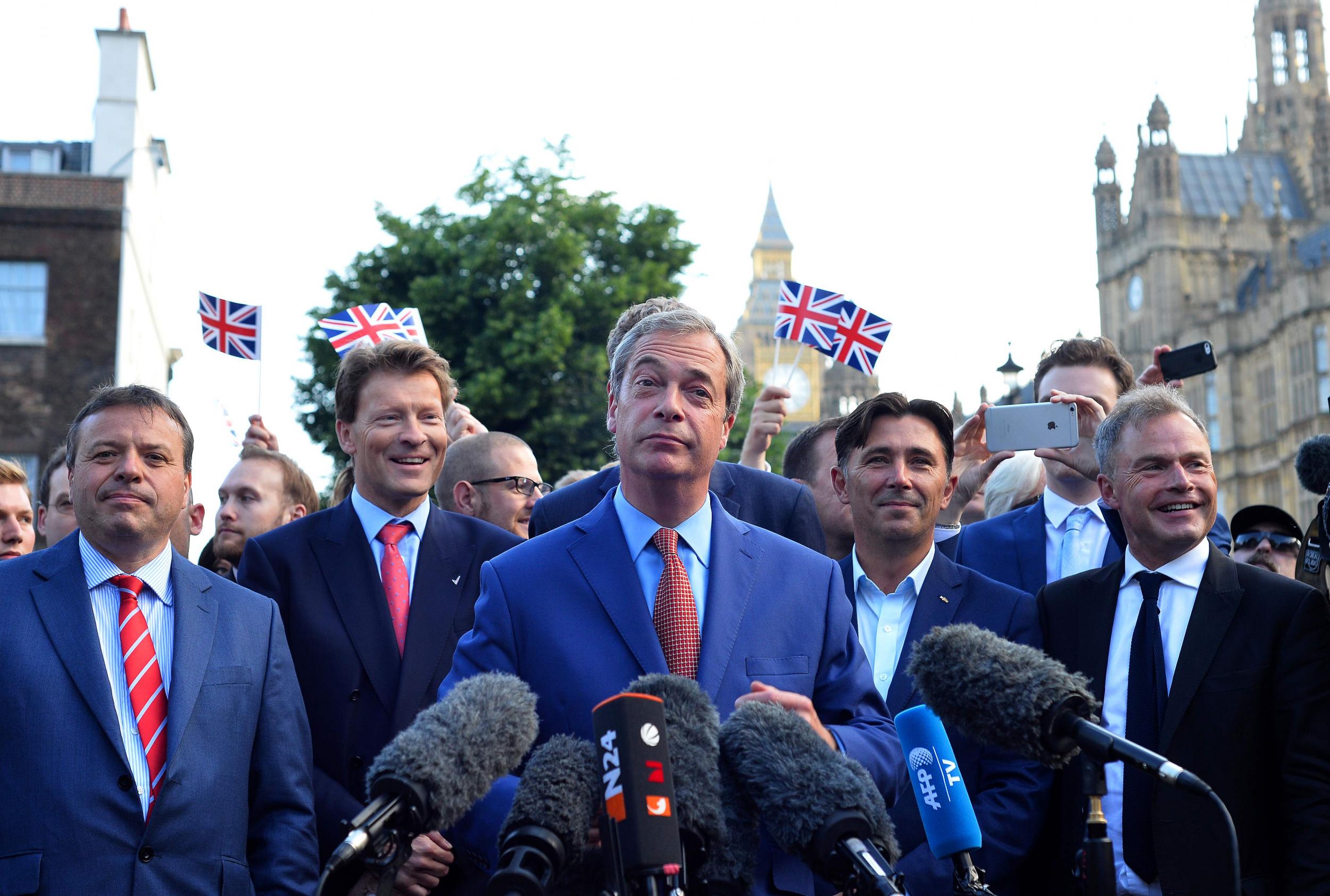 Nigel Farage (C) speaks during a news conference near the Houses of Parliament