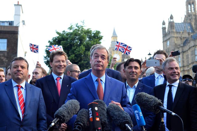 Nigel Farage (C) speaks during a news conference near the Houses of Parliament