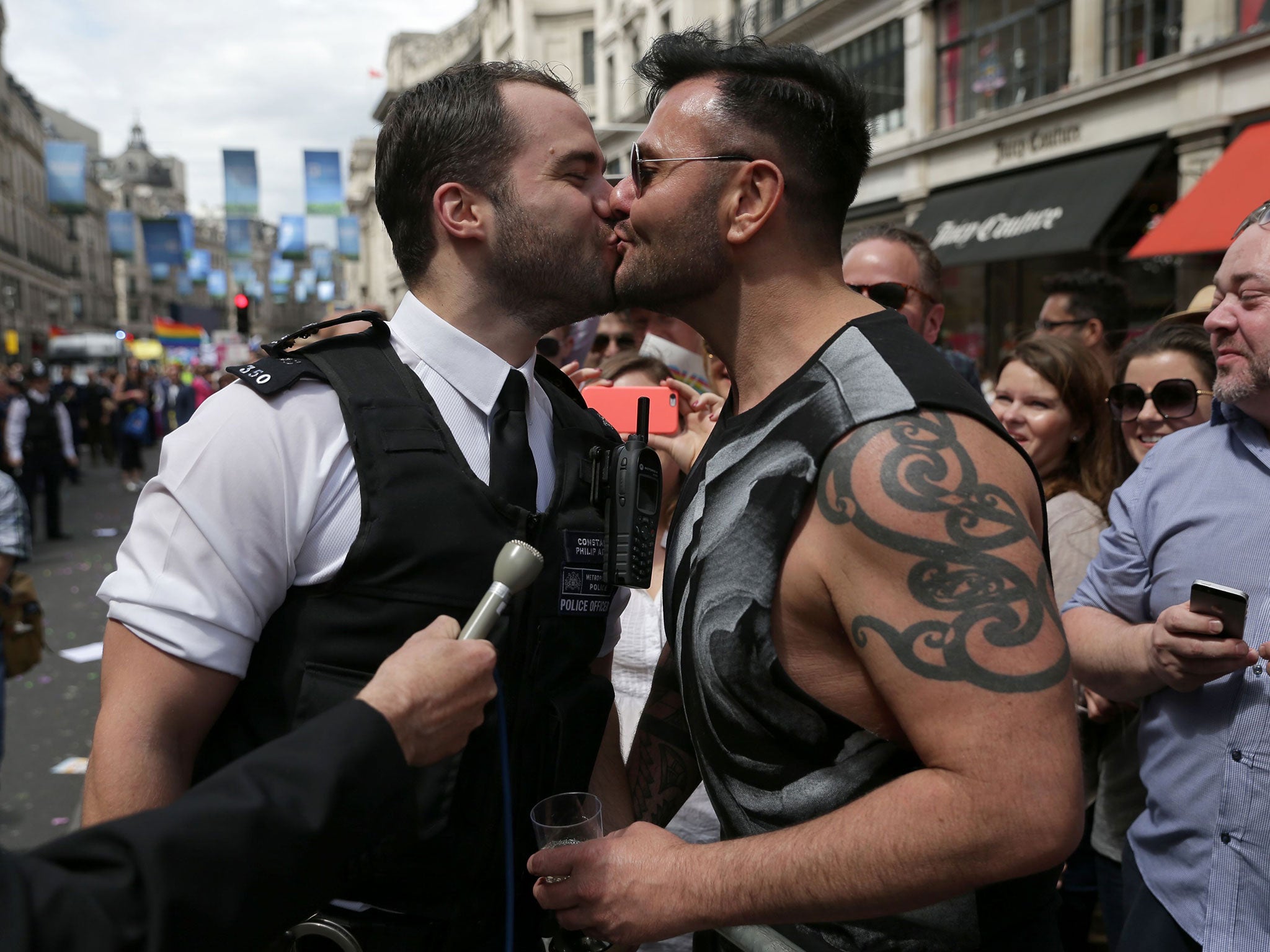 A policeman kisses his fiance after proposing to him during the Pride in London parade, as it makes its way through the streets of central London.