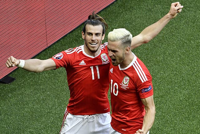 Gareth Bale celebrates with Aaron Ramsey after Gareth McAuley's own goal