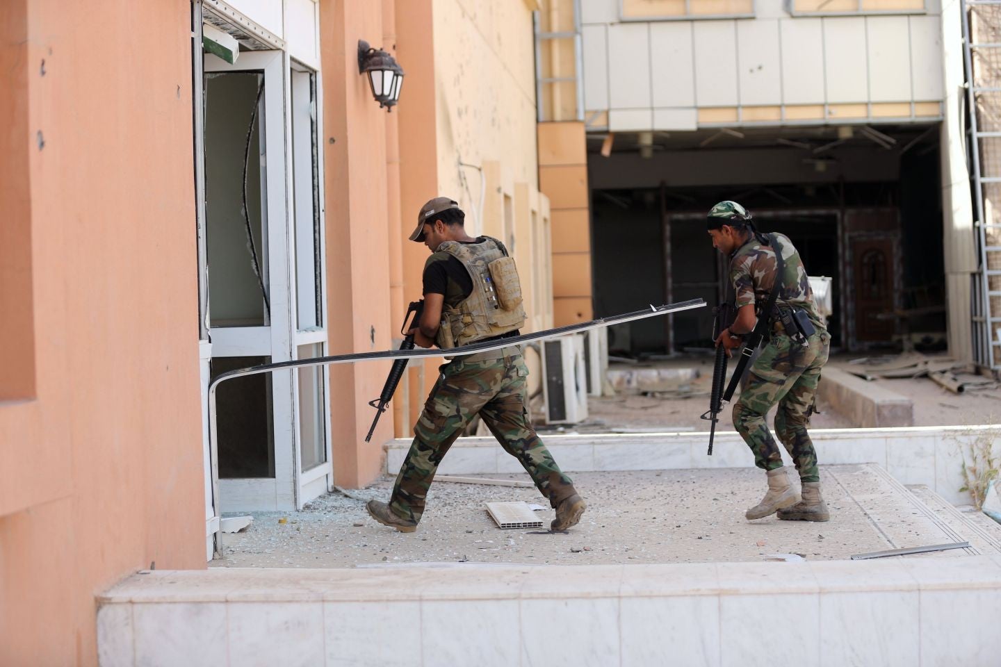 Two Iraqi soldiers enter the main hospital in Fallujah. Isis have controlled the since January 2014