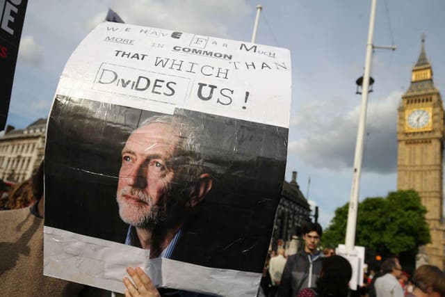 A protester holds up a placard in support of Leader of the opposition Labour Party Jeremy Corbyn outside parliament during a pro-Corbyn demonstration in central London on June 27, 2016